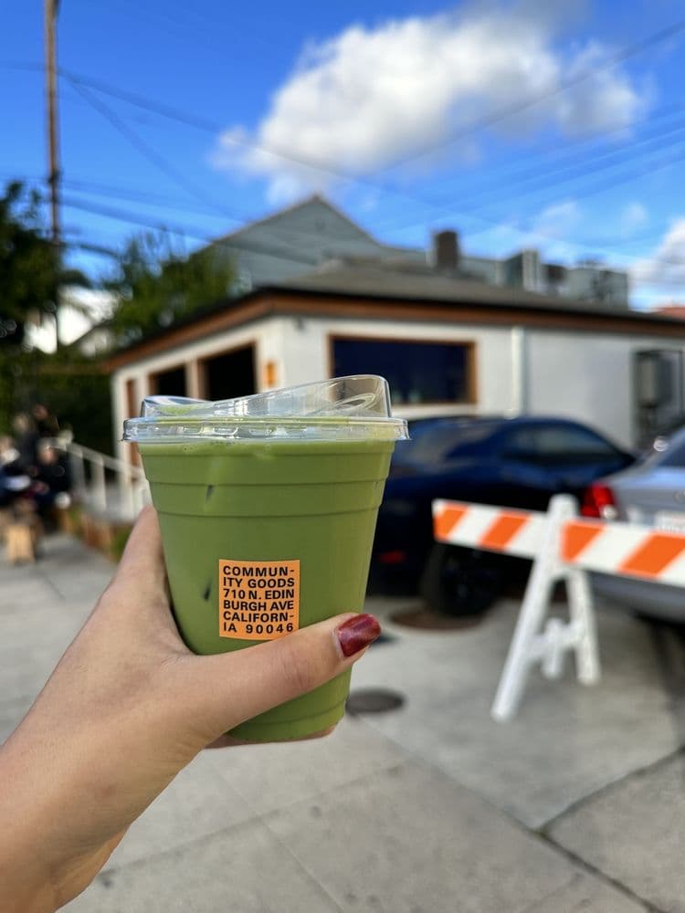 Iced matcha drink with storefront in background